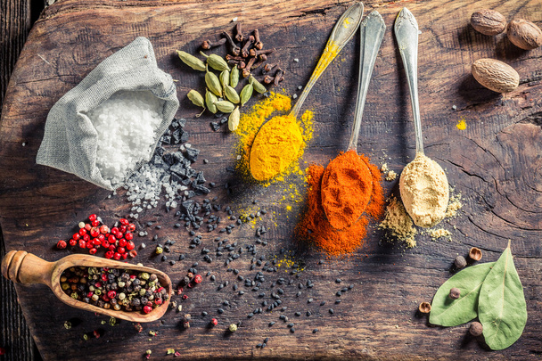 Colorful herbs and spices on old board - Photo, image