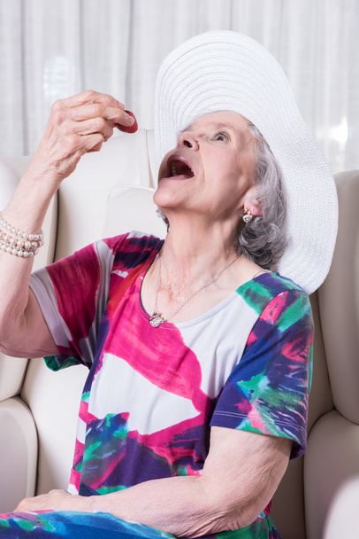 активна жінка старша їсть полуницю
 - Фото, зображення