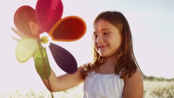 Tyttö ulkona leikkii värikäs tuulimylly lelu
 - Materiaali, video
