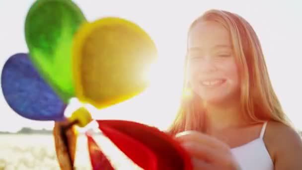dívka si venku hraje s hračkou barevné větrný mlýn - Záběry, video