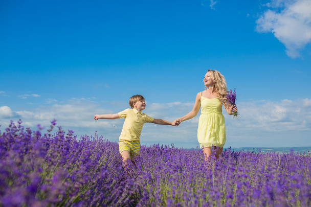 Mother with little son on lavender field - Foto, afbeelding