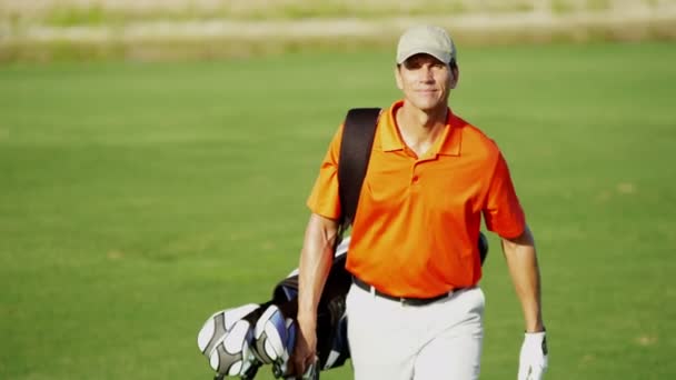 παίκτης γκολφ περπάτημα με εξοπλισμό γκολφ - Πλάνα, βίντεο