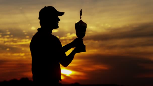 sziluettjét professzionális férfi golf-lejátszó a trófea - Felvétel, videó