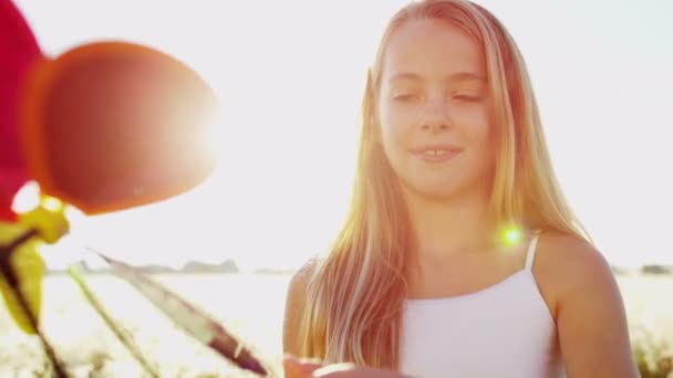 menina ao ar livre jogando com colorido moinho de vento brinquedo
 - Filmagem, Vídeo
