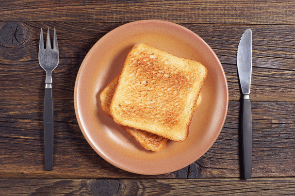 Toasted bread, fork and knife - Foto, afbeelding
