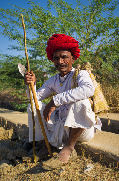 tribesman with red turban sits - Фото, зображення