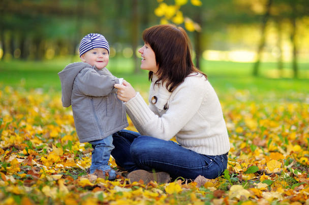 Genç anne ile bebeği sonbahar parkta - Fotoğraf, Görsel
