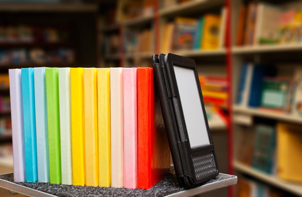 Row of colorful books with electronic book reader - Photo, Image