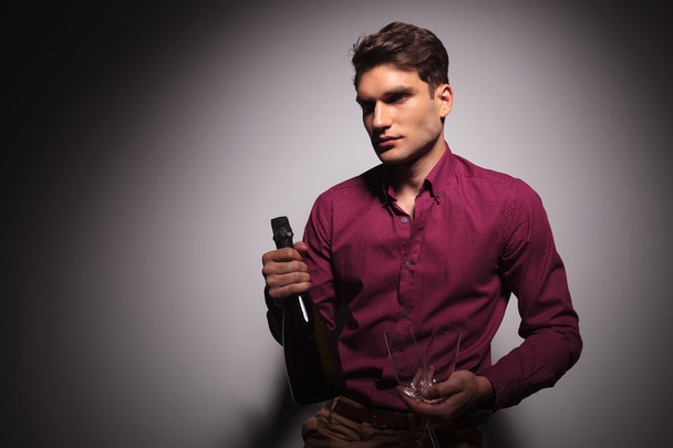 young handsome man holding a bottle of wine - Φωτογραφία, εικόνα