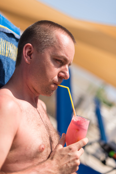 Handsom hombre bebiendo una bebida en una piscina del hotel
 - Foto, imagen