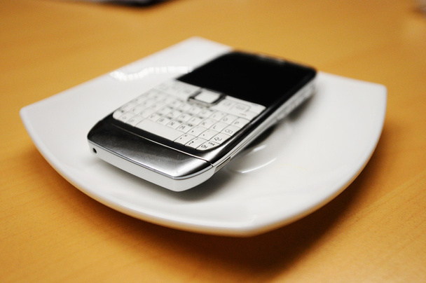 Teléfono inteligente viejo en placa blanca
, - Foto, imagen