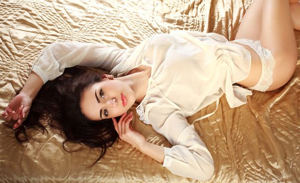 Jeune femme sensuelle en lingerie couchée sur le lit
 - Photo, image