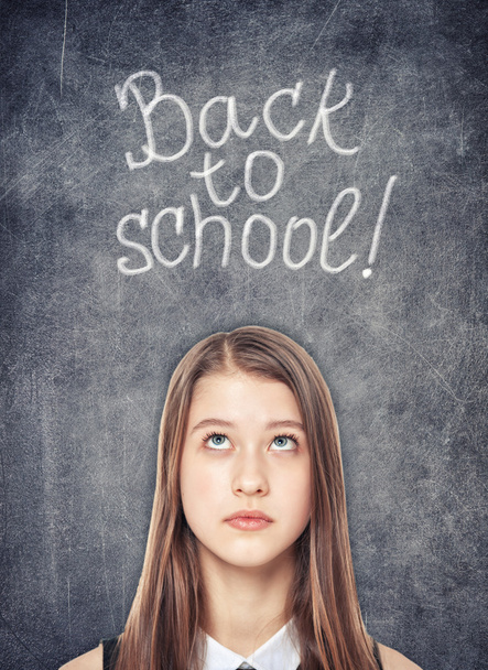 Teenage school girl looking up on the chalkboard background - Zdjęcie, obraz
