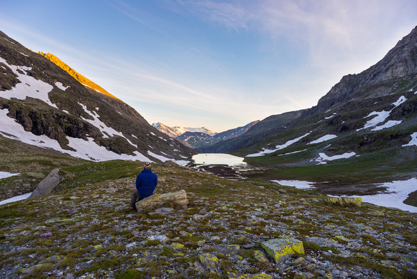 Una persona mirando el amanecer en lo alto de los Alpes
 - Foto, Imagen