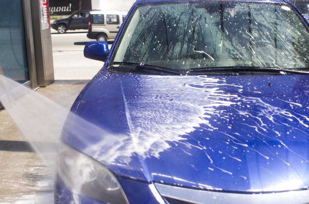 Autowaschanlage mit fließendem Wasser und Schaum. - Foto, Bild