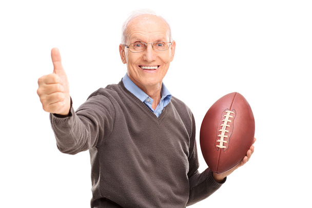 Senior holding a football and giving thumb up  - Valokuva, kuva