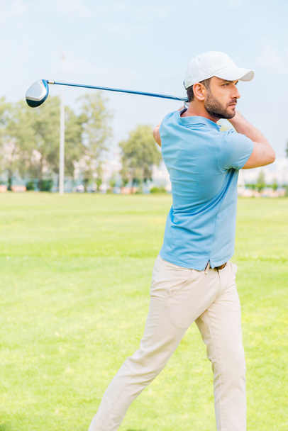 Confident young man playing golf - 写真・画像