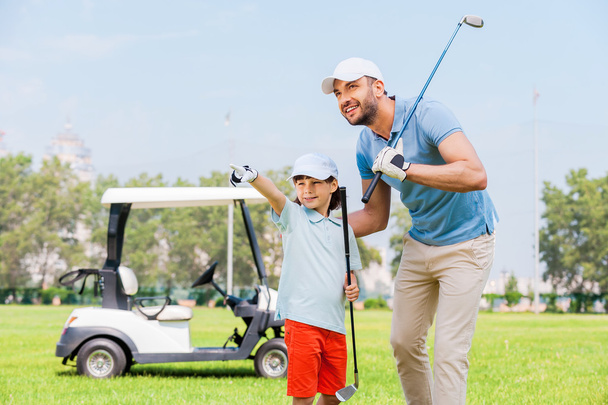 man embracing his son on  golf course - 写真・画像