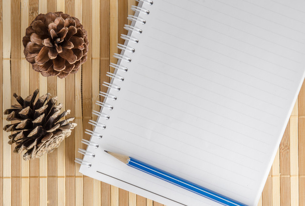 Üres jegyzék jegyzetfüzet ceruzával barna bambusz háttér - Fotó, kép