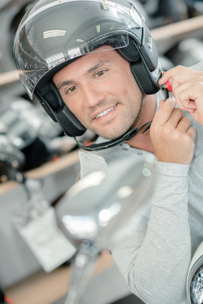 Trying on a motorcycle helmet - Photo, image