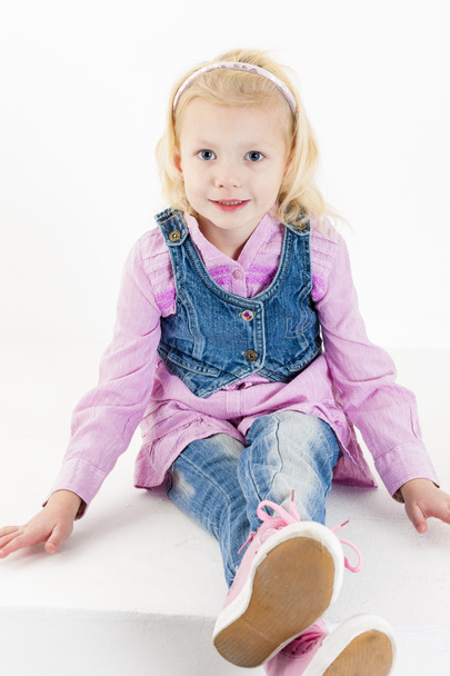 sitting little girl wearing jeans - Foto, imagen