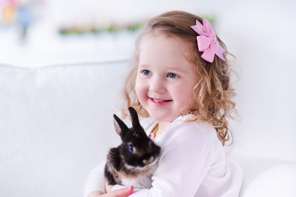 Little girl playing with a real pet rabbit - Foto, Imagem