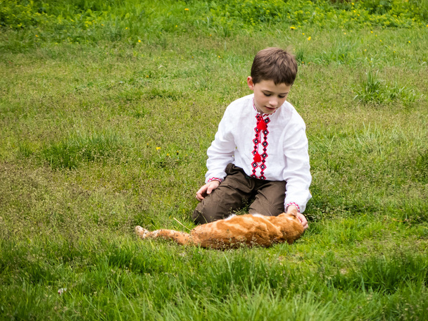 Um menino com um gato vermelho
 - Foto, Imagem