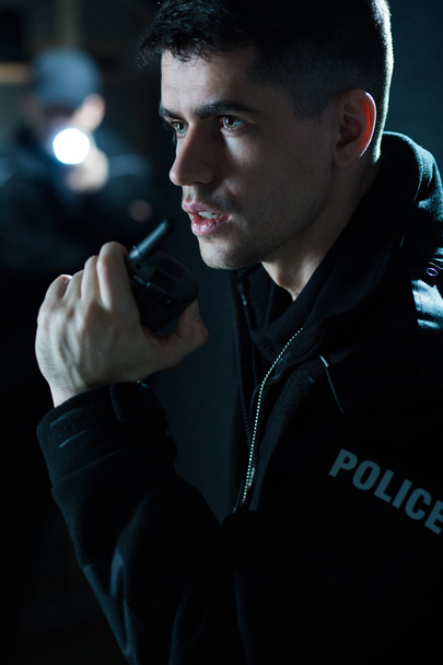 Police officer holding radio - Valokuva, kuva