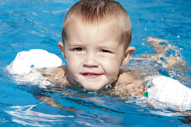 Portrait of little baby boy swimming in the swimming pool - Fotó, kép