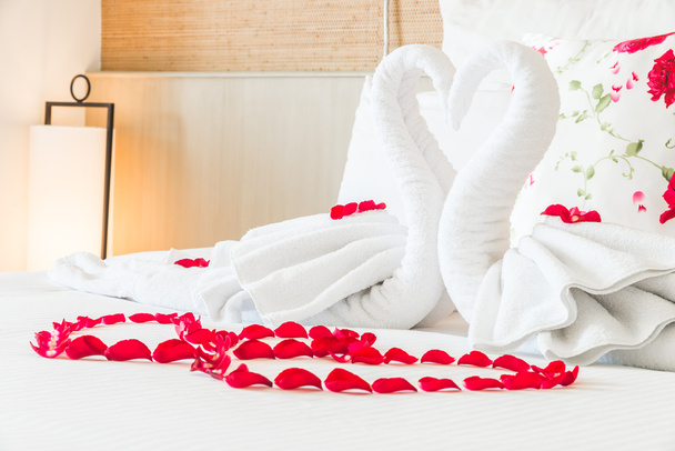 Πετσέτα κύκνοι και ροδαλά λουλούδια σε κρεβάτι - Φωτογραφία, εικόνα