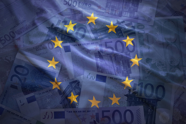 カラフルなユーロのお金の背景に欧州連合の旗を振っています。 - 写真・画像