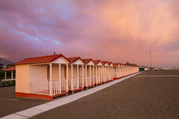 Cabaña de playa de Forte dei Marmi en un atardecer de cielo púrpura
 - Foto, Imagen