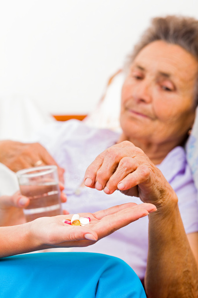 Elderly woman taking pills - Fotó, kép