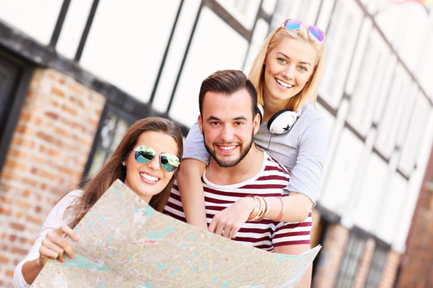 Happy friends sightseeing with map - Photo, Image