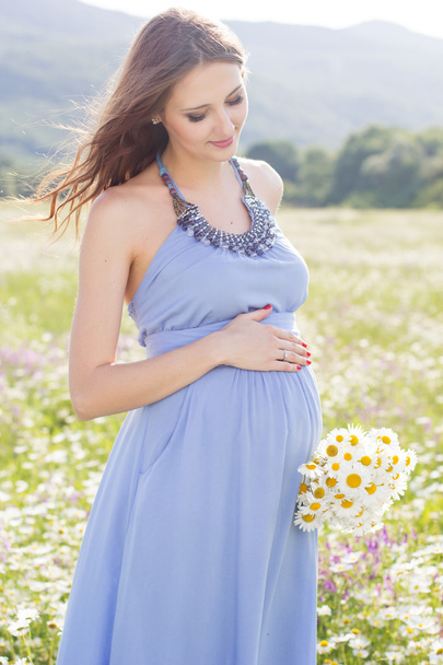 Pregnant woman with bouquet of daisy flowers - Zdjęcie, obraz