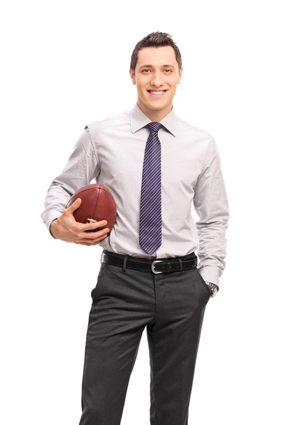 Vertical shot of a young businessman holding a football  - Φωτογραφία, εικόνα