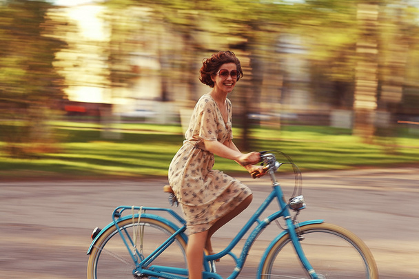 Girl on bike at sunset - Foto, afbeelding