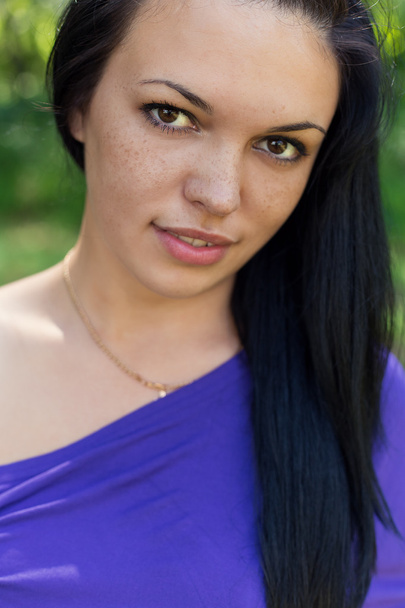 Porträt eines schönen süßen Mädchens mit Sommersprossen und langen schwarzen Haaren mit gebräunter Haut - Foto, Bild