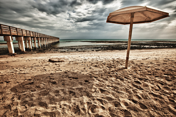 Umbrella and Pier at the Beach - Photo, Image