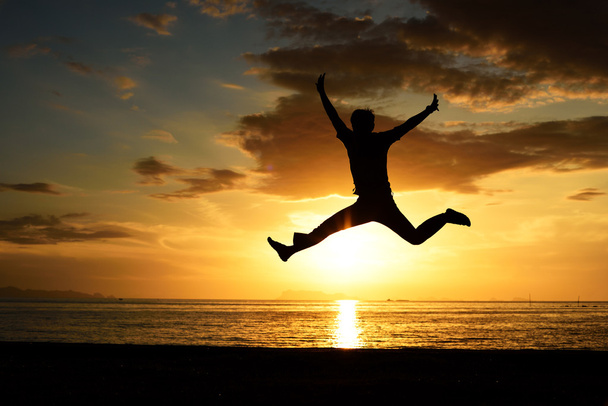 Силуэт прыгающего человека на пляже
 - Фото, изображение