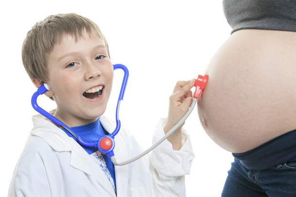 Joyful little brother listening stethoscope belly - Fotó, kép