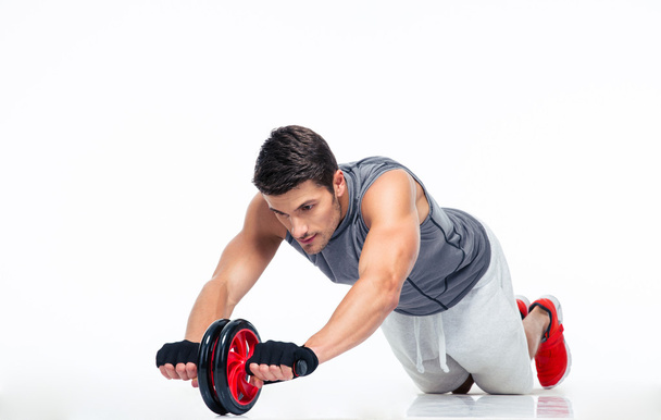 Man workout with fitness wheel on the floor  - Valokuva, kuva