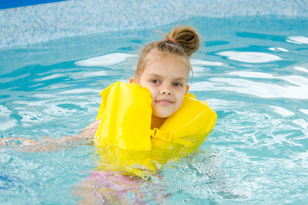 Девушка плавает в бассейне в спасательной рубашке
 - Фото, изображение