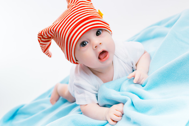 toddler in a striped hat on a blue blanket - Photo, image