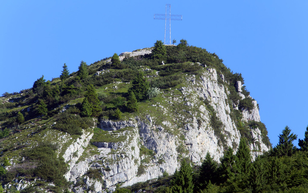 гора в северной Италии с крестом над вершиной
 - Фото, изображение