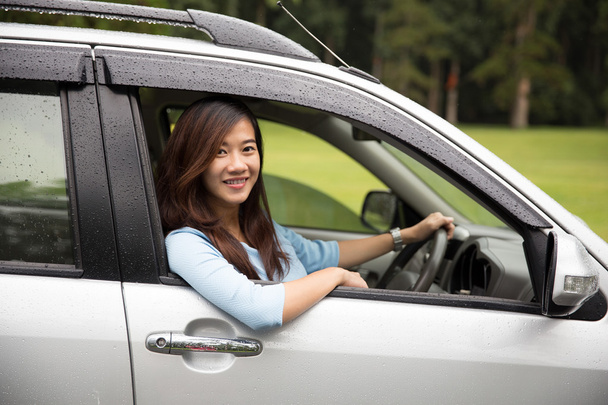 Happy young asian woman riding a car - 写真・画像