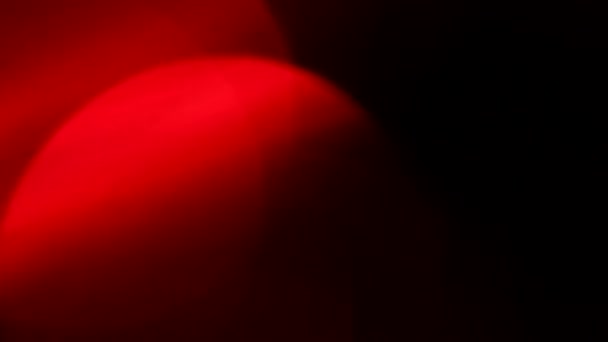 Mozgó piros defókuszált fények keresztül sötét háttér. - Felvétel, videó
