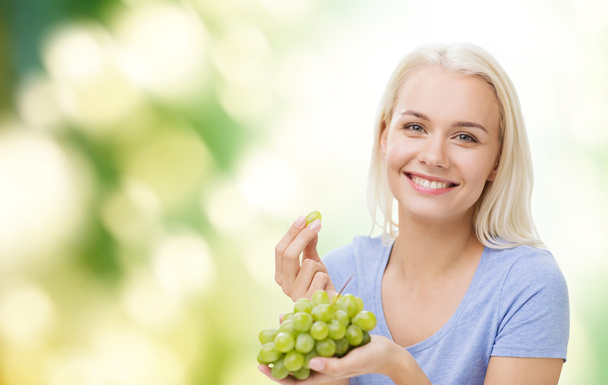happy woman eating grapes - Foto, afbeelding