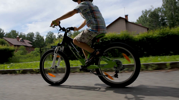 Młody chłopak w hełm jazdy na rowerze - Materiał filmowy, wideo