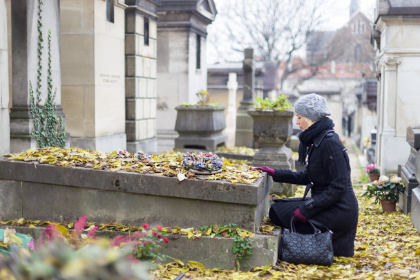 Mujer solitaria visitando tumba parientes
. - Foto, Imagen